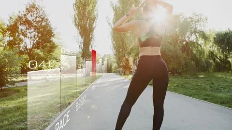 Runner tracking performance while jogging in a park during daylight hours Stock Photos