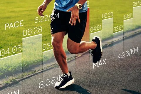 Runner tracks performance data while jogging on a track field in the afternoon Photos