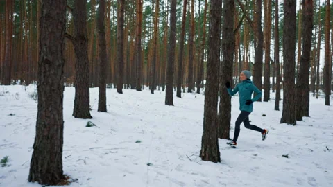 Runner trains on snowy road Stock Footage 228595753