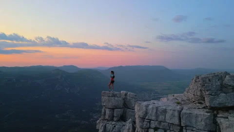 Runner Triumphantly Standing on Cliff at Sunset Stock-Footage 314202294