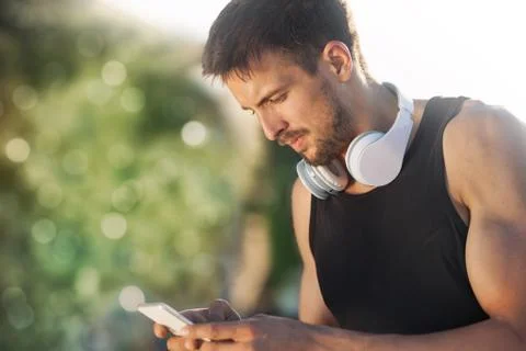 Runner typing something on his mobile Stock Photos