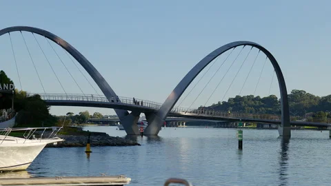 Runner, walkers cross dual span bridge over river, boat and bridge in background Video stock 204060903