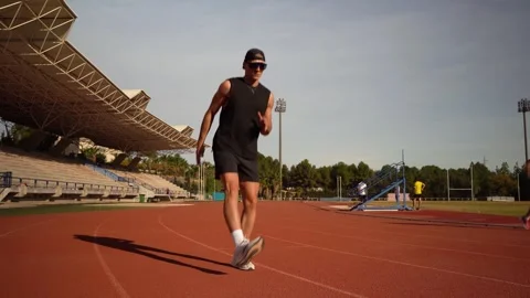 Runner warming up before training on a running track in the early morning. .. Stock Footage 267894509