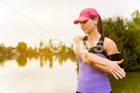 Runner woman stretching a pier at sunset. Stock Photos