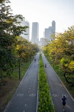 Runners and cyclists using divided park road in bangkok Foto stock