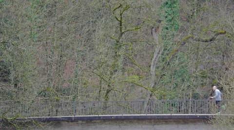 Runners crossing a bridge with forest backdrop Stock Footage 58853708
