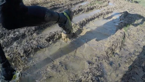 Runners going through ice in a muddy puddle while on a trail run 動画素材 112006187