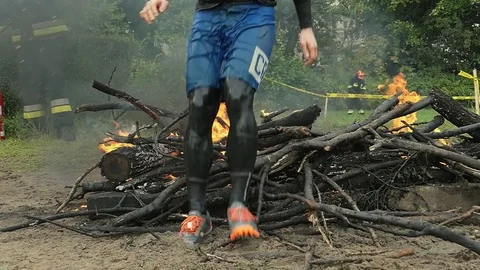 Runners Jumping Over Burning Obstacle in Endurance Race Slow Motion Stock Footage 85390943