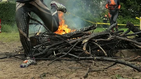 Runners Jumping Over Burning Obstacle in Endurance Race Slow Motion Stock Footage 85399510