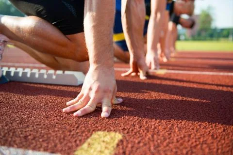 Runners preparing for race at starting blocks Stock Photos