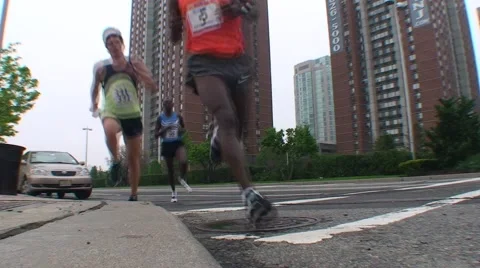 Runners in race by camera, low angle Stock Footage 51056194