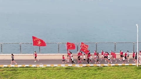 Runners with red flags on reservoir ring road Stock Footage 341738728