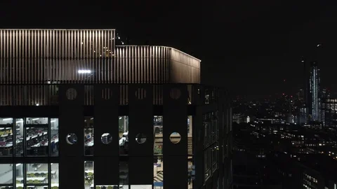 Runners on rooftop running track at night side on view, drone aerial 4K Video stock 101169787