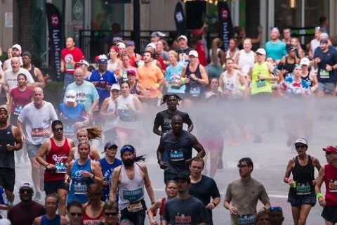 Runners run through cooling mist at Atlanta Peachtree Road Race Stock Photos