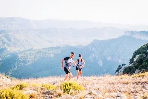 Runners running down the mountain in the running gear in the race. Stock Photos