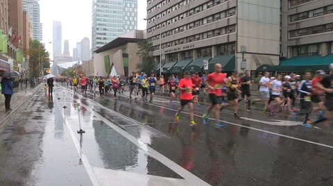 Runners running in the heavy rain downtown in Toronto Stock Footage 68626701