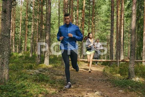 Runners running on trail in woods Stock Photos
