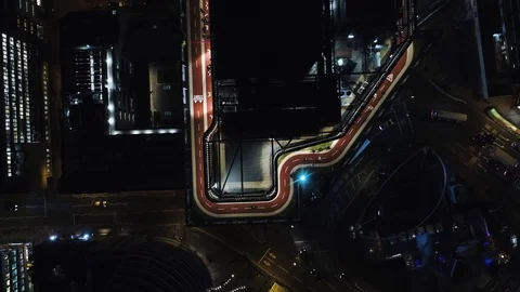Runners starting race around rooftop running track at night, drone aerial 4K Stock Footage 101171361