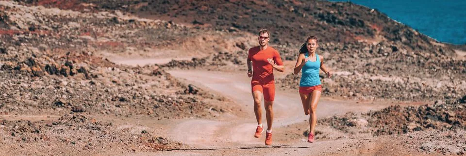 Runners training trail running fast in desert landscape panoramic banner. Couple Stock Photos