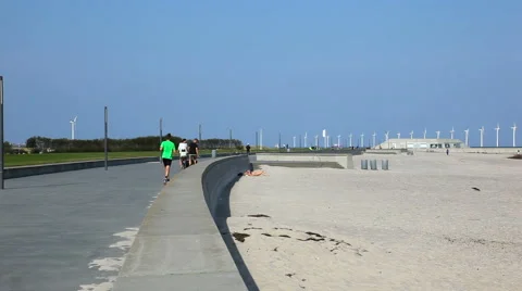 Running along the beach towards the wind turbines Video stock 41821976