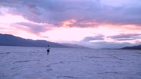 Running and Dancing on Salt Flats at Sunset Video stock 136773641