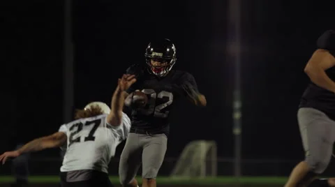 A running back football player jumps over his opponents to score a touchdown. Stock Footage