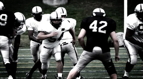 A Running Back receives a handoff and spins to avoid a defender Video stock 33863669