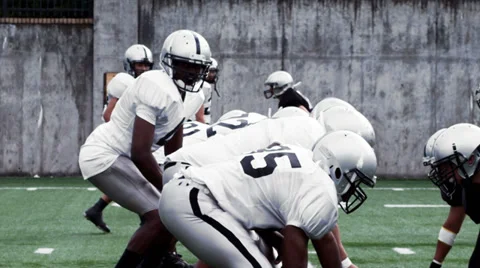 A Running Back receives a handoff and sidesteps defenders before being tackled. Stock Footage 33863784