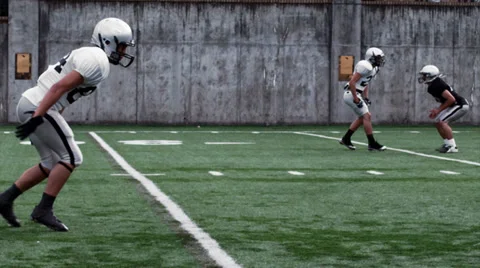 A Running Back receives a handoff and sidesteps and spins passed defenders Video stock 33863903