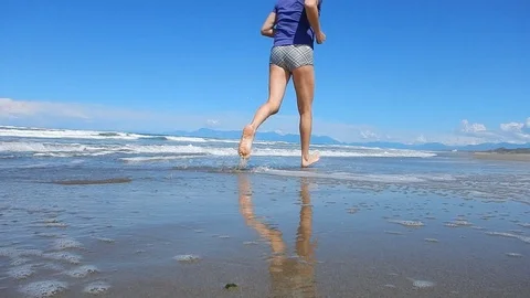Running barefoot on the beach going 4617 Stock Footage 107951399