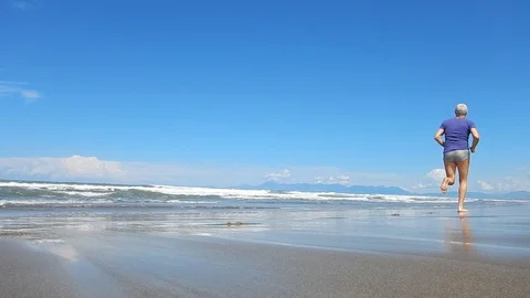 Running barefoot on the beach going 4624 Stock Footage 107972005