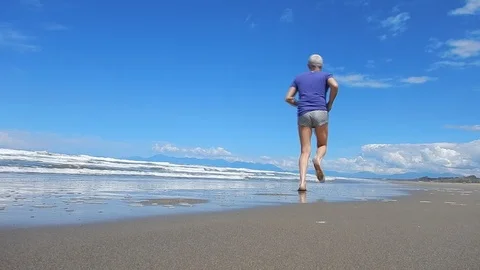 Running barefoot on the beach going 4627 Stock Footage 107972111