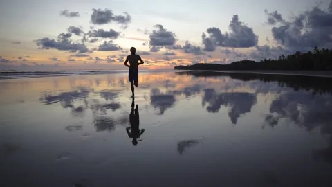 Running on the beach in front of a beautiful sunset Stock Footage 151704511