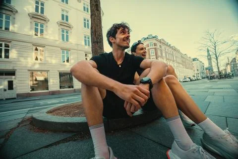 The running break after training shows a man and woman at rest in the city Stock Photos