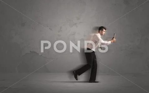 Running businessman with device in hand Stock Photos