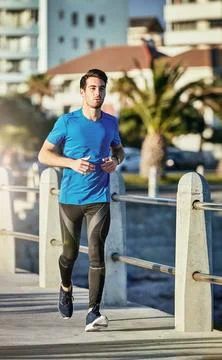 Running can benefit almost every part of your body. a sporty young man out for a Stock Photos