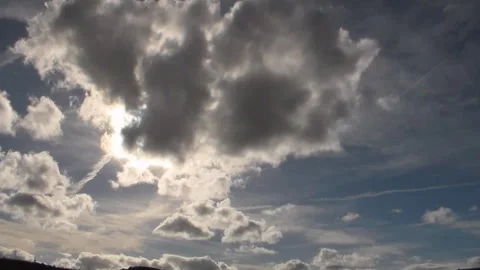 Running clouds in sunny sky with a inversion traces from an airplane. Stock Footage 92582387