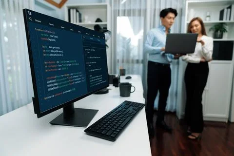Running coding screen with blurry IT developers standing with laptop. Infobahn. Stock Photos