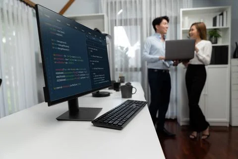 Running coding screen with blurry IT developers standing with laptop. Infobahn. Stock Photos