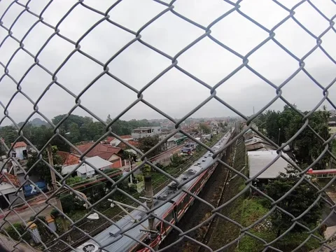 Running Commuter Train Behind Wire Fence, Bogor, Indonesia Stock Footage 151236356