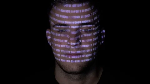Running digital binary data code reflected on the face of a young man working Stock Footage 86434981