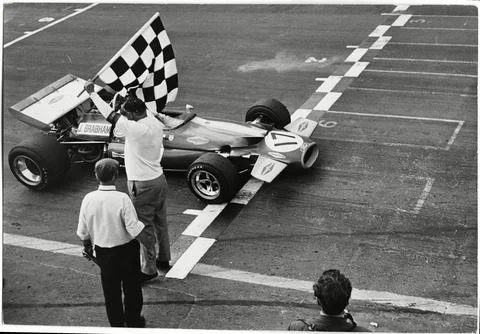 Running On Empty. An Unlucky Jack Brabham Splutters Across The Line Out Of Fuel  Stock Photos