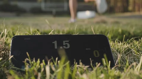 Running in a field while setting a timer on a cellphone in the grass Stock Footage 312723807