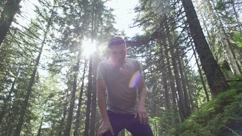 Running in the forest, a rest stop. Man jogging on a sunny day Stock Footage 236689296