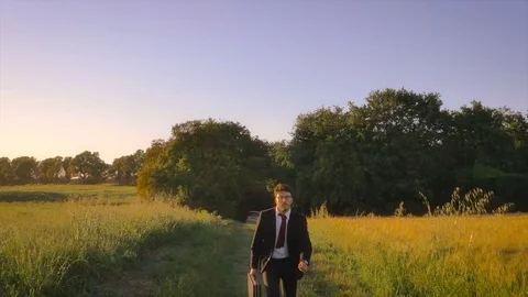Running to the future. Young businessman in the middle of the nature Stock Footage 76772152