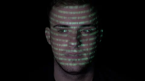 Running green programming code reflected on the face of a young calm male com Stock Footage 86434976