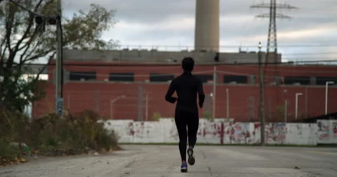 Running jogging into the distance in urban setting Vidéo 138455375