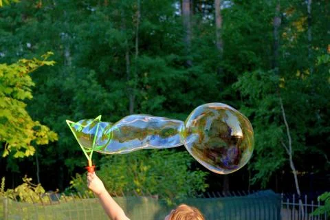 Running a large soap bubble.	2 Stock Photos