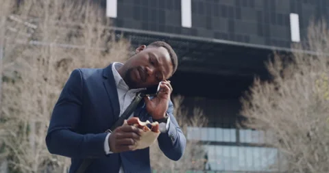 Running late, talking on phone and eating lunch while checking watch, feeling Stock Footage 255078651