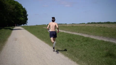Running Man. A bare-chested man runs along a green meadow. Video stock 269958441
